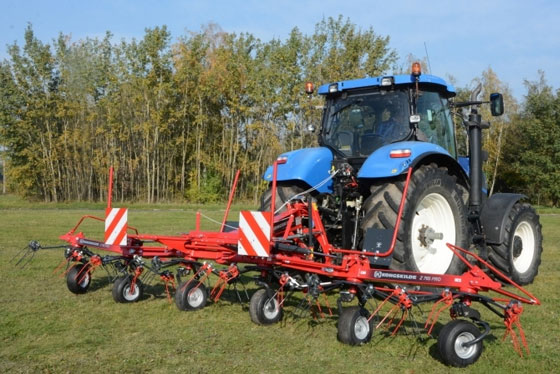 kongskilde zettwender mit traktor vorne hintergrund bäume und feld