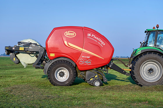 vicon press und wickeltechnik anhänger und traktor auf grünen feld