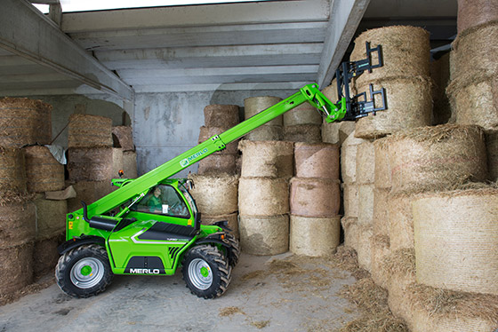 merlo teleskopstapler stapelt heuballen in halle